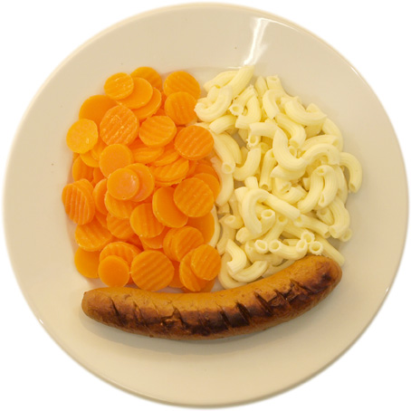 A sausage with little pasta and lots of carrots